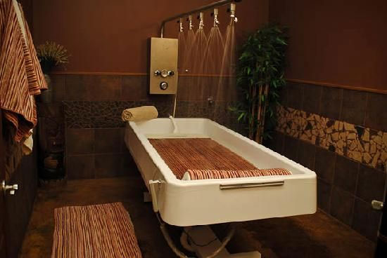Spa hydrotherapy room with Water Werks Cascade 5 Head Vichy Shower and soothing brown decor.