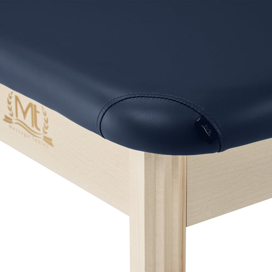 Close-up of MT Massage HARVEY Stationary Table with navy high-density foam and light wood frame.