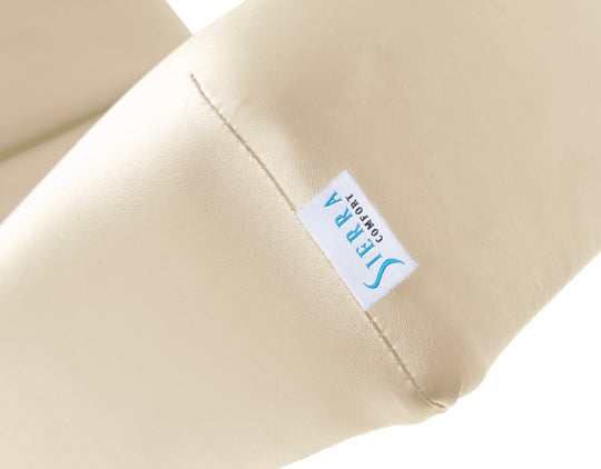 Beige pillow with a visible brand label on a white background