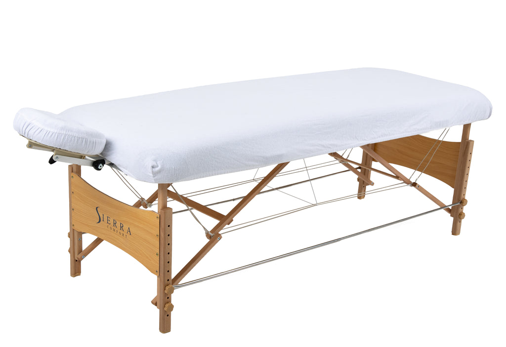 Sierra Comfort Premium Wide Portable Massage Table with white sheet and face cradle, by Sierra Comfort.