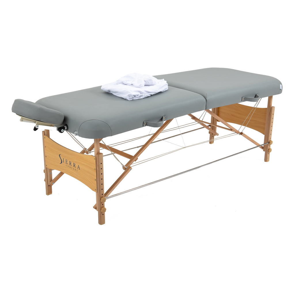 Sierra Comfort Premium Wide Portable Massage Table with wooden legs and folded white towel.