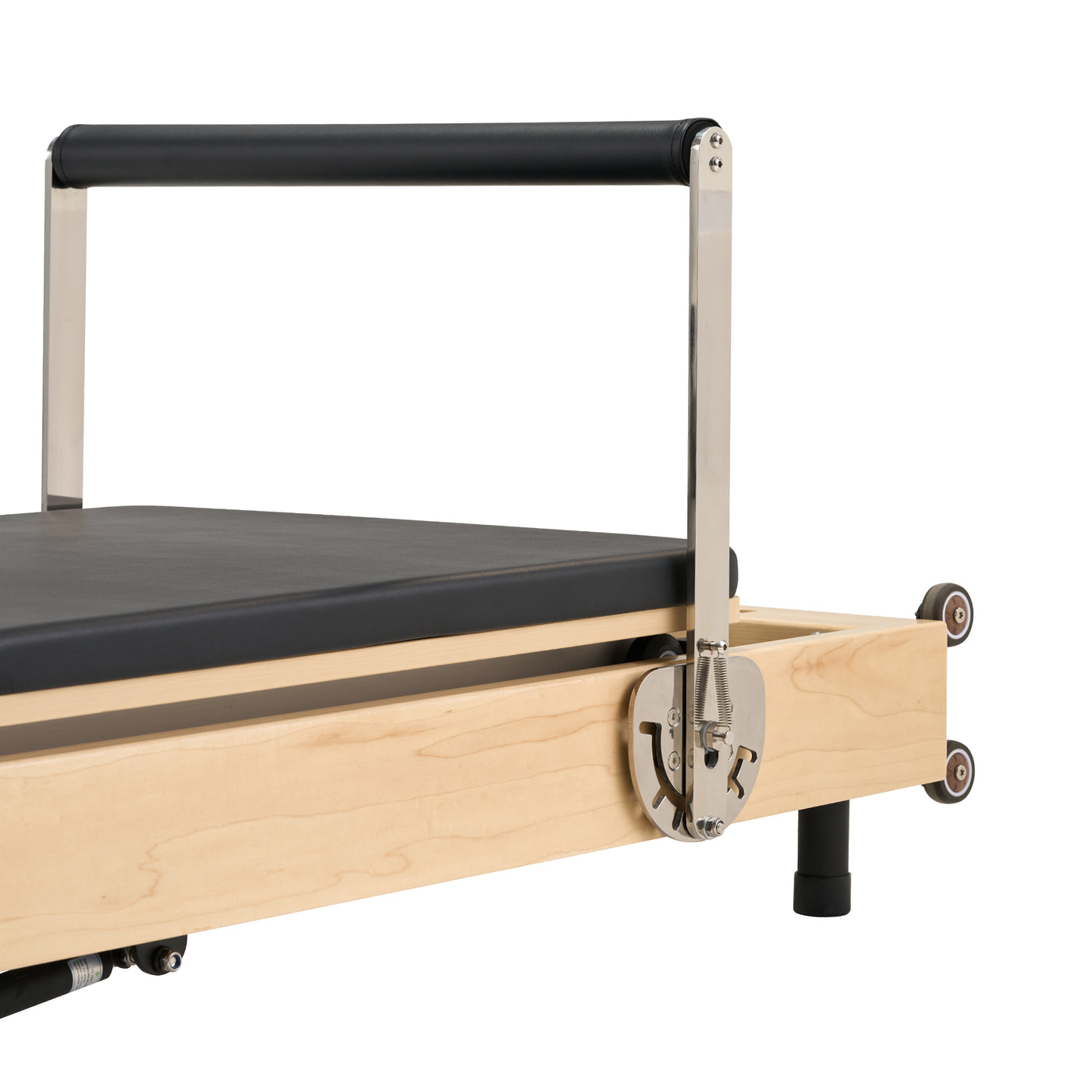 Pilates reformer with wooden frame and black cushion on a white background