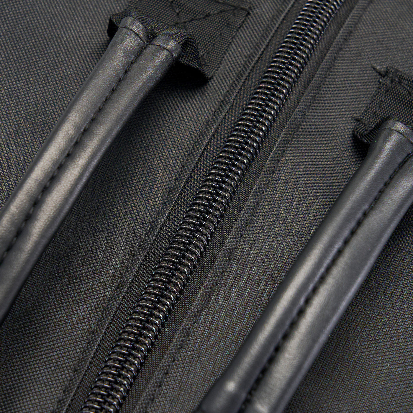 Close-up of a black bag with zippers and handles