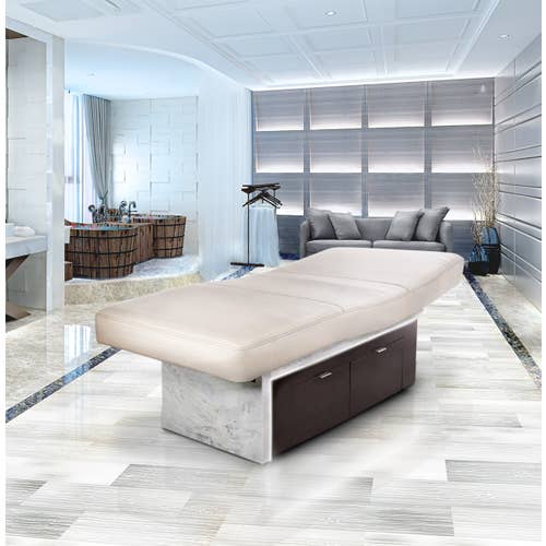 Modern spa room with a Living Earth Crafts INSIGNIA 2.0 Waterfall treatment table and marble floors.