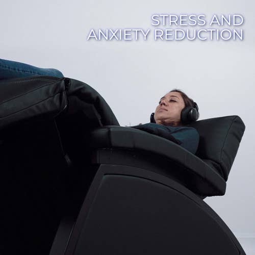 A woman relaxes in the Living Earth Crafts Mind-Sync 2.0™ Harmonic Wellness Lounger with headphones.