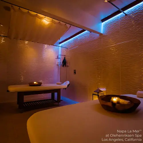 Spa room with Living Earth Crafts Napa La Mer teak base table, candles, and textured white walls.