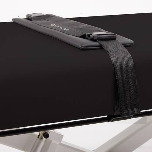 Black padded strap on EarthLite ELLORA Flat Massage Table with Stretch Assist System.