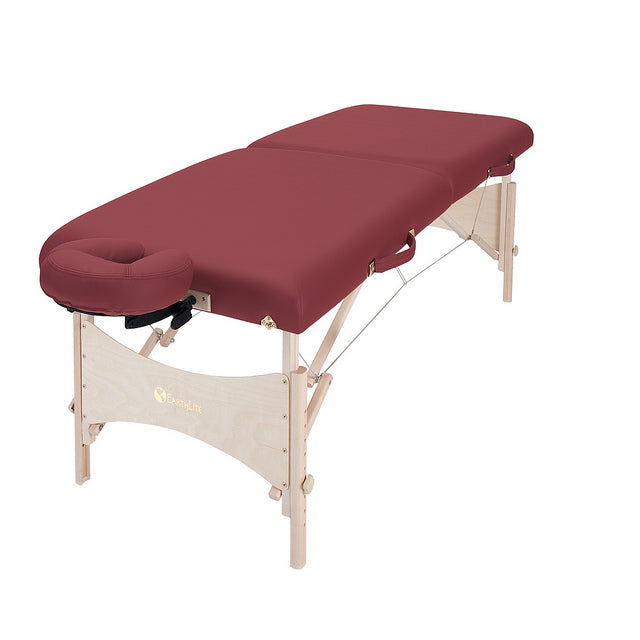 The EarthLite HARMONY DX is a portable massage table with wood legs and a burgundy cover.