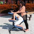 A woman enjoys a seated massage outdoors on the Master Massage RIO Portable Massage Chair.
