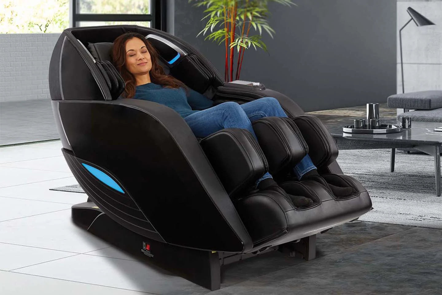 A woman relaxes in a Kyota Yutaka™ M898 4D Electric Massage Chair in a modern living room.