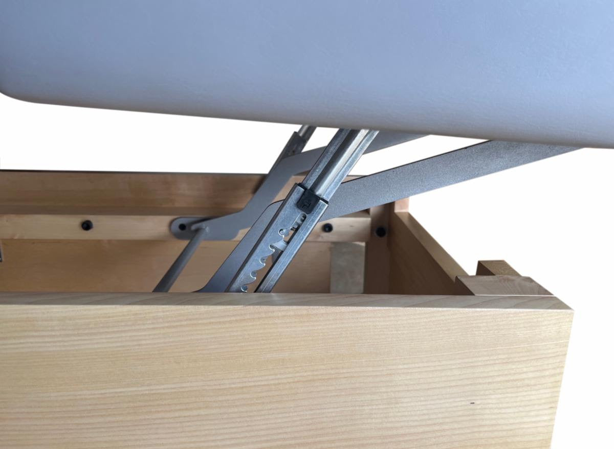 Close-up of a metal hinge on a TouchAmerica SONDI Treatment Table, partially opened.