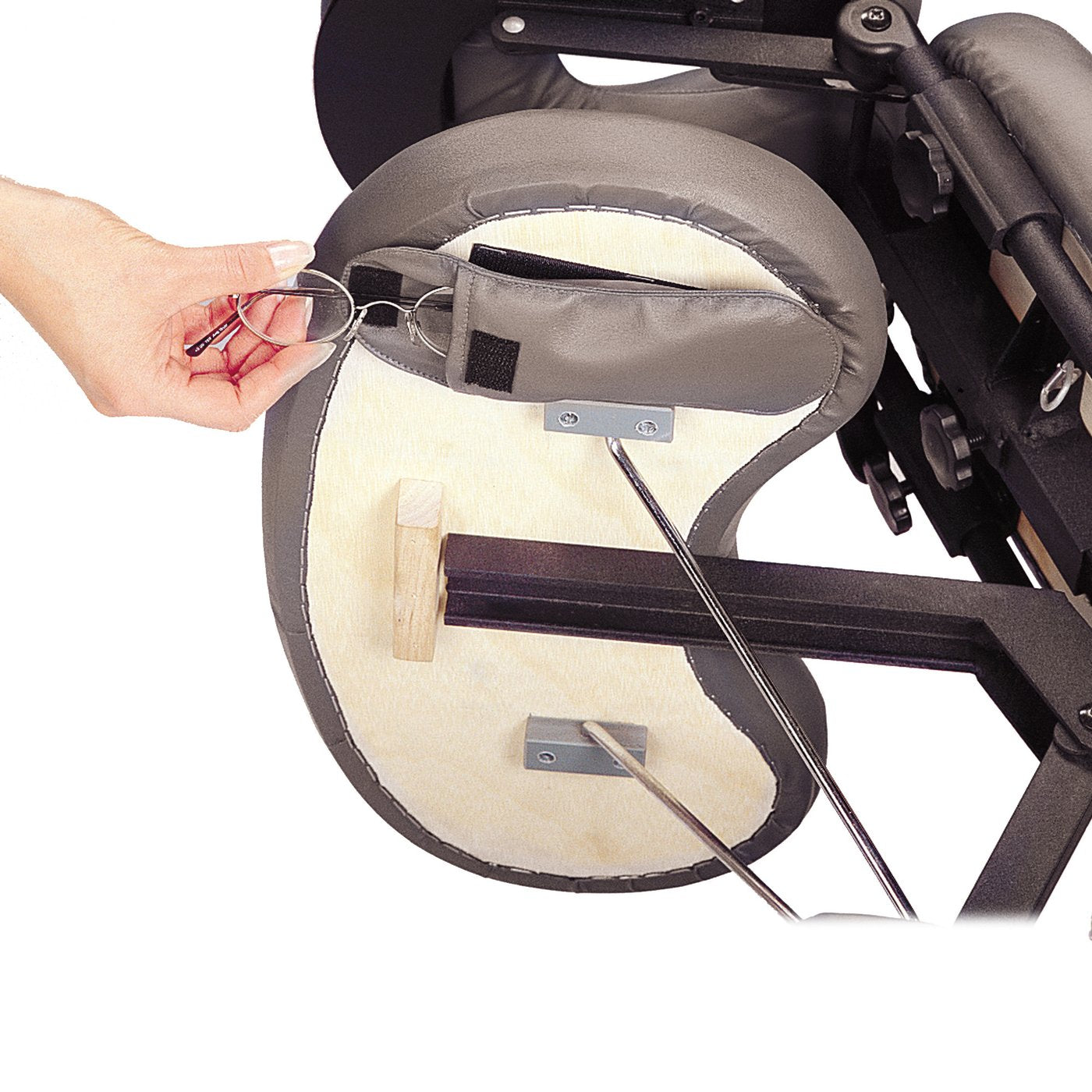 A hand places eyeglasses into a pocket on the Master Massage APOLLO XXL chair’s headrest.