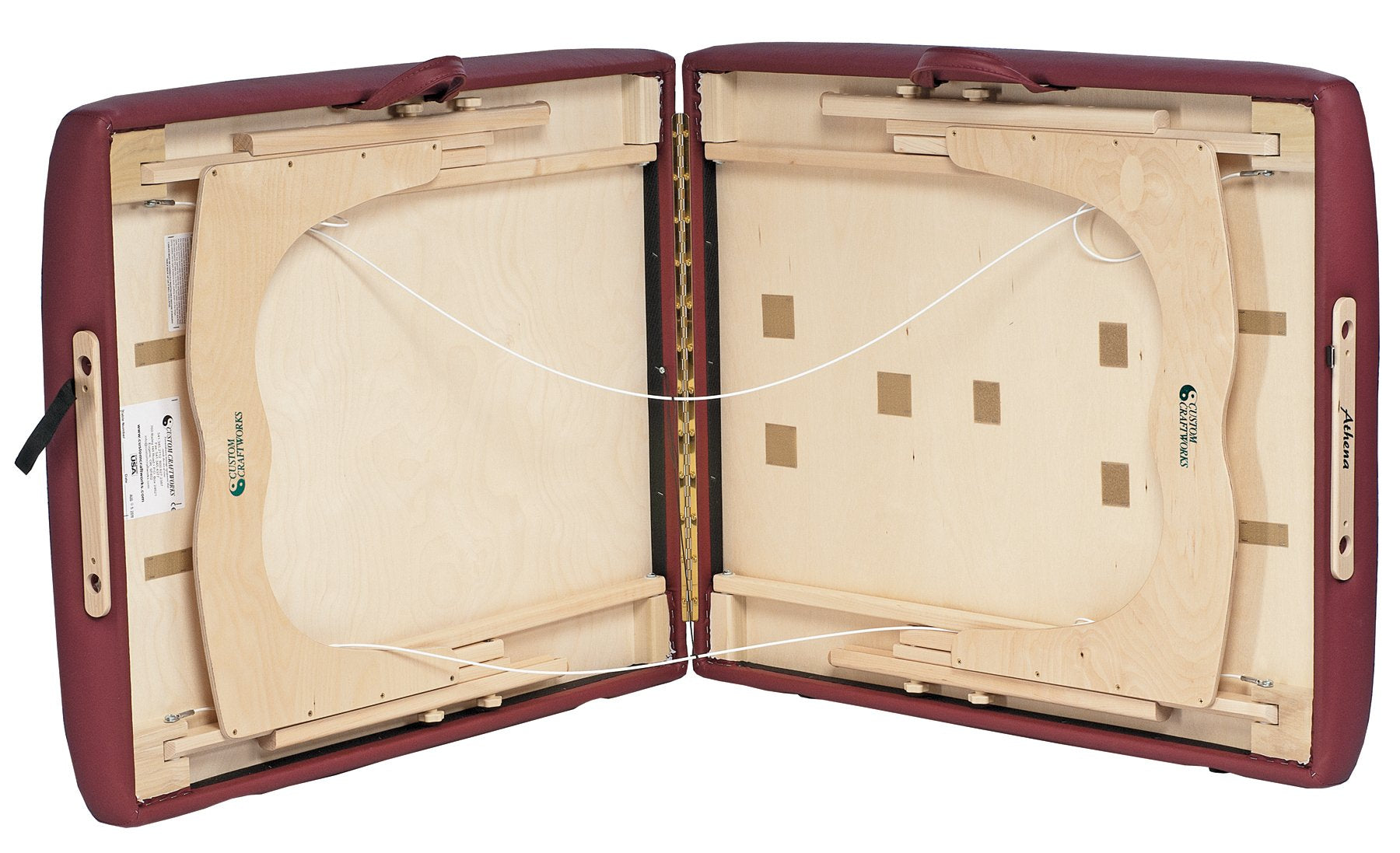 Custom Craftworks ATHENA massage table open, revealing wooden frame and support cables.