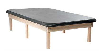 The PHS Chiropractic Classic Wood Mat Table - 6 Leg offers minimalist, modern comfort.