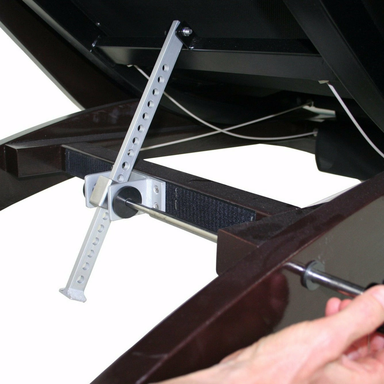 Adjusting the lever on the TouchAmerica Breath Pedi-Lounge’s dark wood frame mechanism.