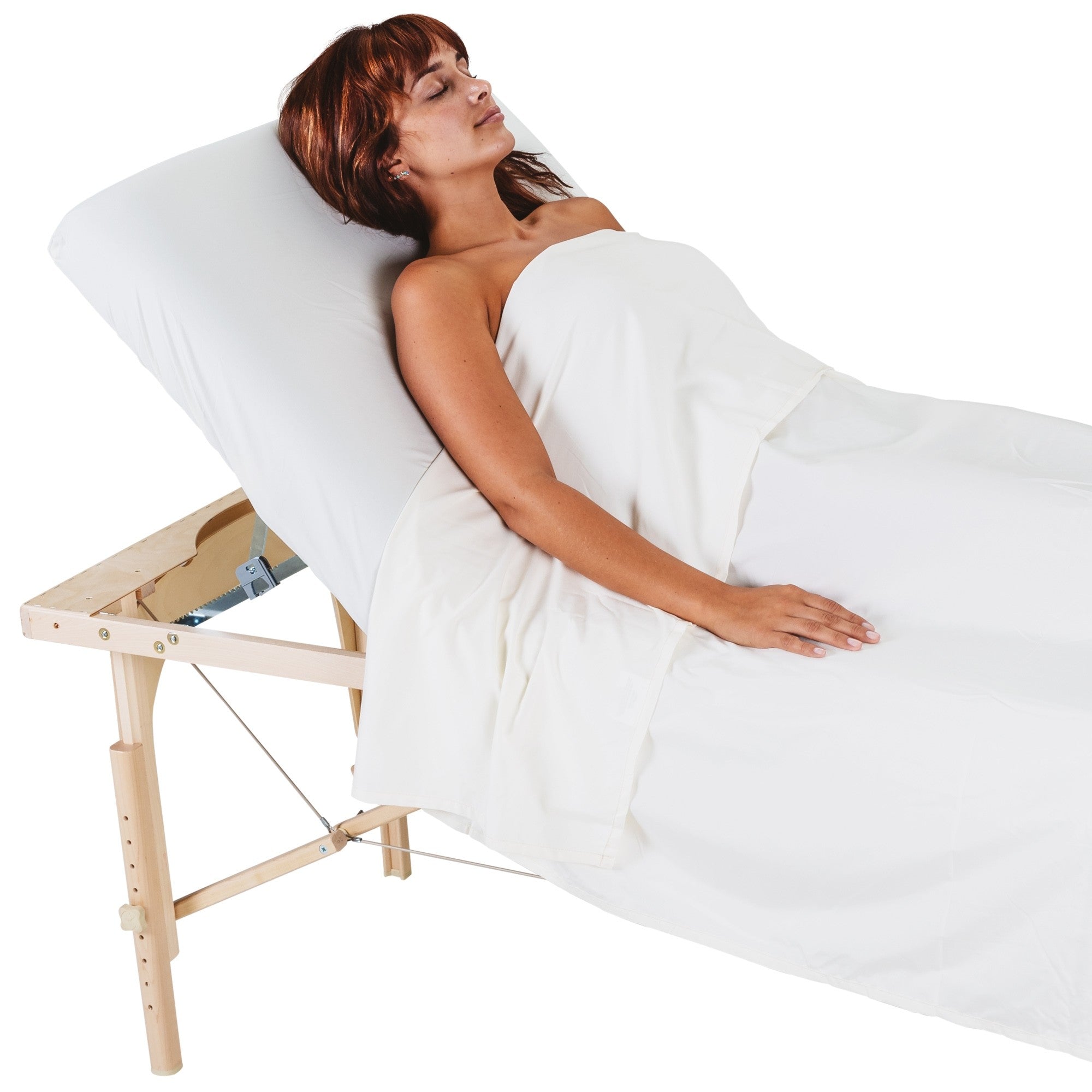 Woman lying on an EarthLite AVALON XD TILT massage table with a white sheet over her.