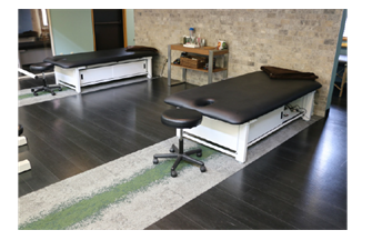 Two PHS ME2001 Bariatric Elevating Tables by PHS Chiropractic and a stool in a modern therapy room.