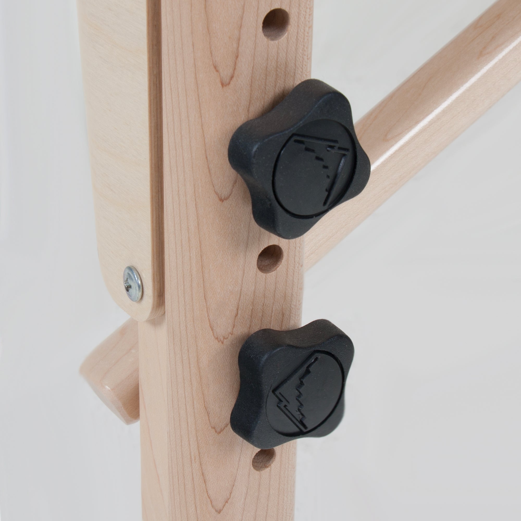 Close-up of two black knobs on the Stronglite CLASSIC DELUXE Table Package’s wooden frame.