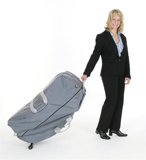 Woman in business attire wheels a Pisces Pro DOLPHIN II Portable Massage Chair against white backdrop.