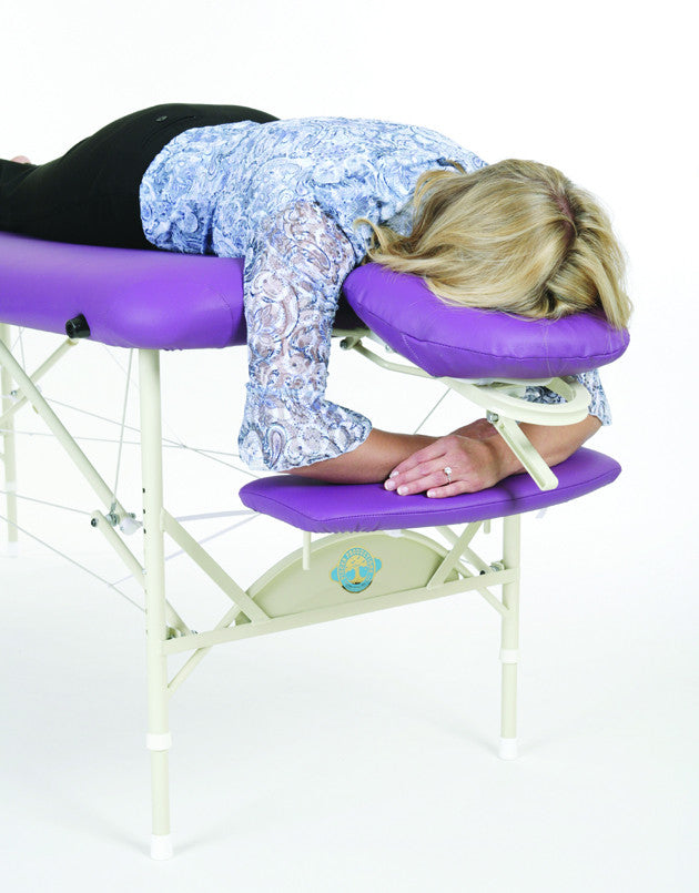 Woman lying face down on a Pisces Pro NEW WAVE II Lite Massage Table with purple cushion.