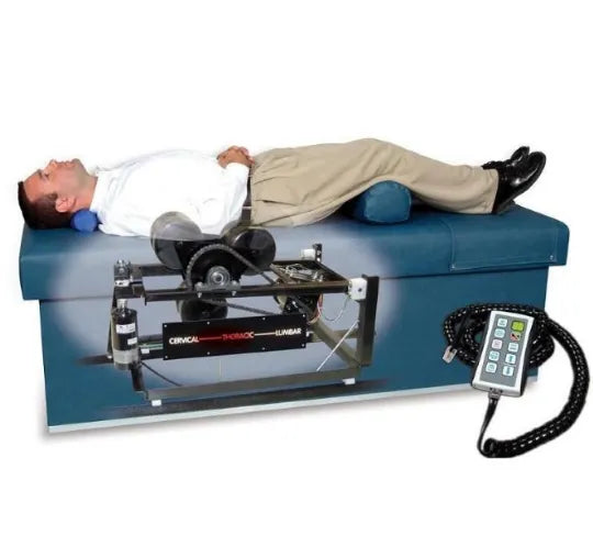 A man lies on an Armedica Quantum 400 Series Intersegmental Traction Table with a control device.