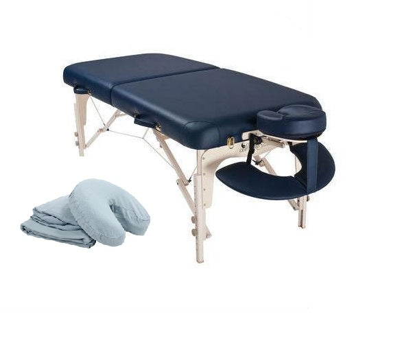 Custom Craftworks LUXOR portable massage table with deluxe face rest and folded sheets nearby.